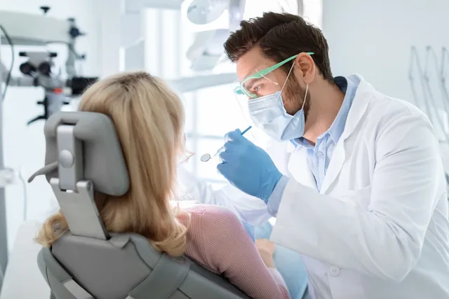A dentist examining a patient in the treatment chair